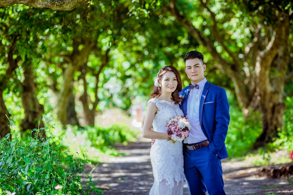 Couple standing under trees in a park